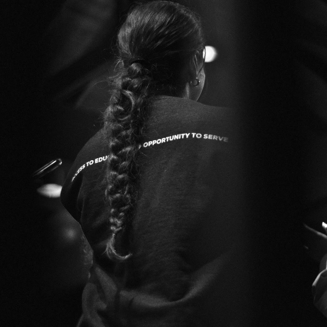 Black-and-white portrait from behind of a person with a long braid
