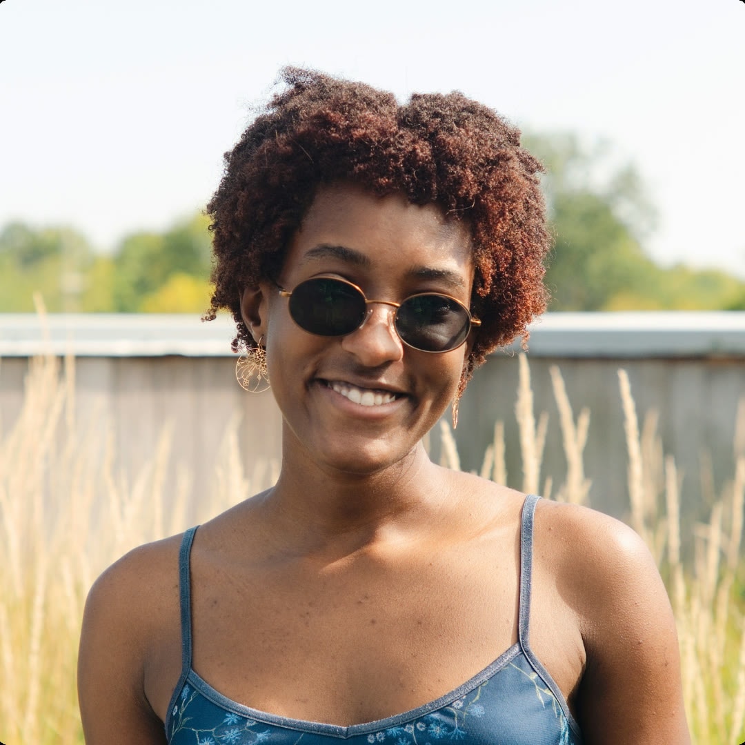 Outdoor portrait of a smiling person wearing sunglasses
